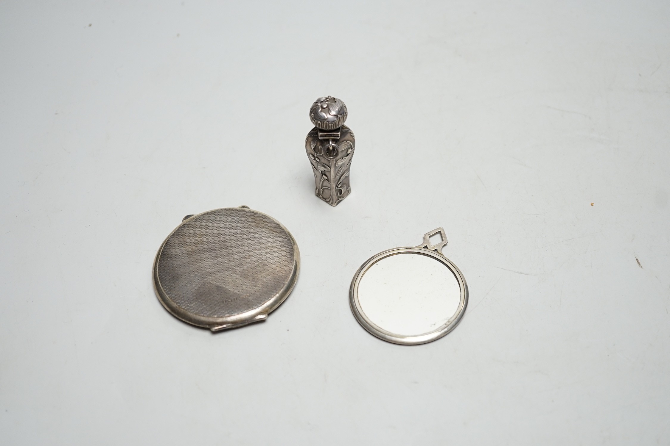 A 1930's silver and enamelled hand bag mirror, London, 1930, 52mm, together with a silver and enamelled compact and a small white metal scent bottle.